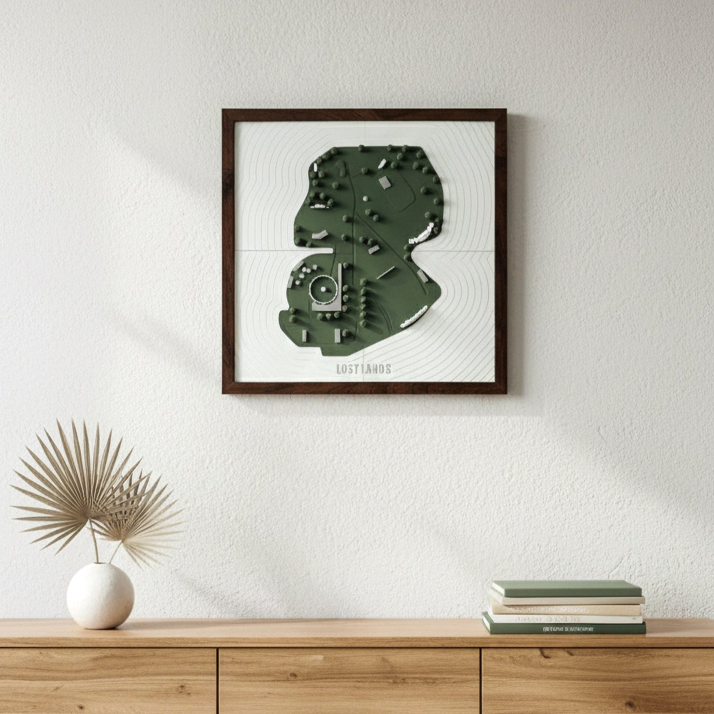 Framed artwork of a green abstract design on a white wall above a wooden console table.