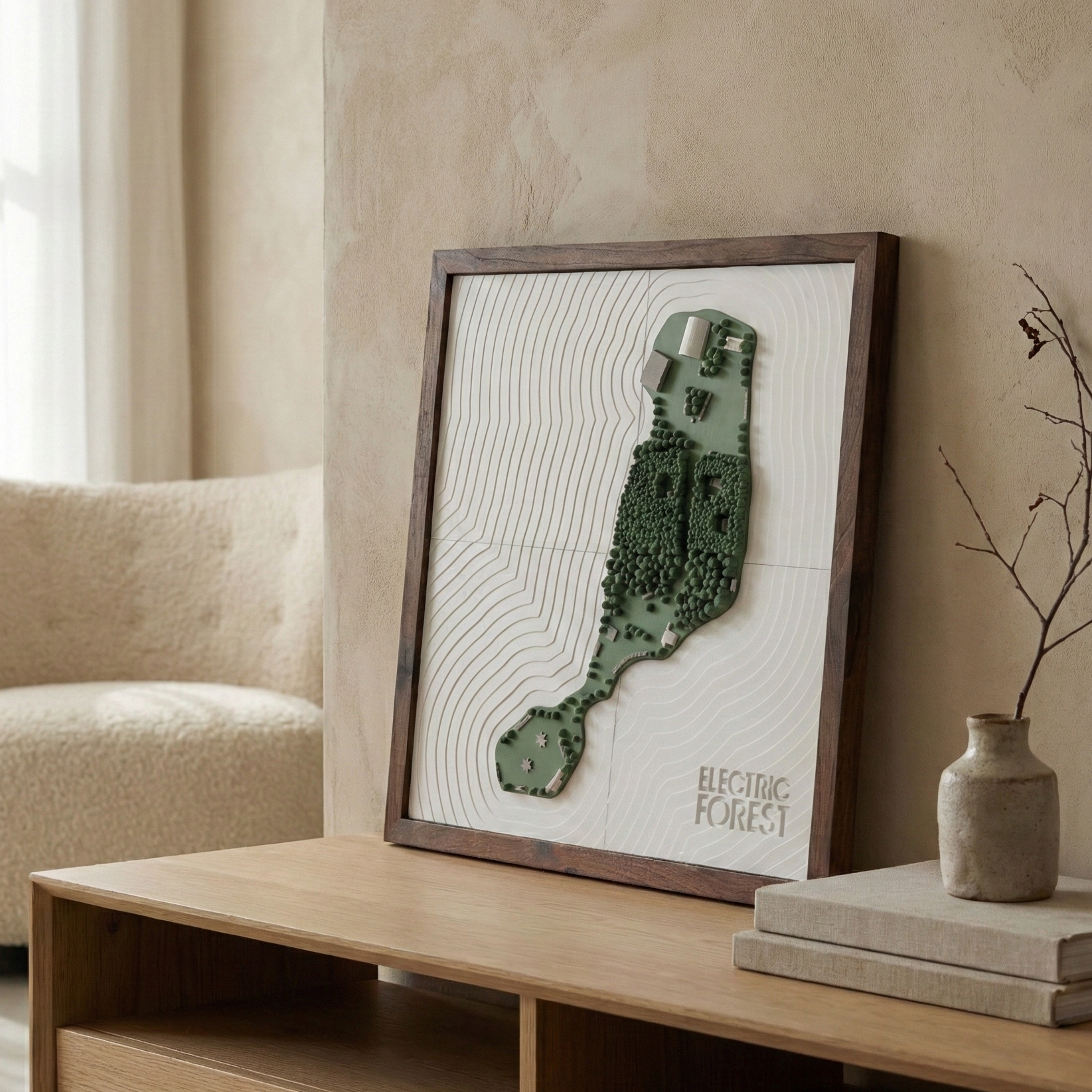 Framed artwork on a wooden shelf in a room with a beige armchair and light-colored walls.