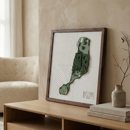 Framed artwork on a wooden shelf in a room with a beige armchair and light-colored walls.