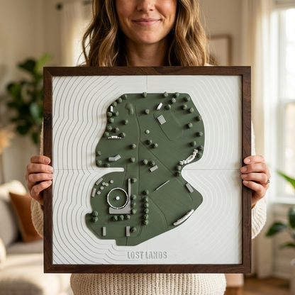 Person holding a framed topographic map of Lost Lands in a living room setting.